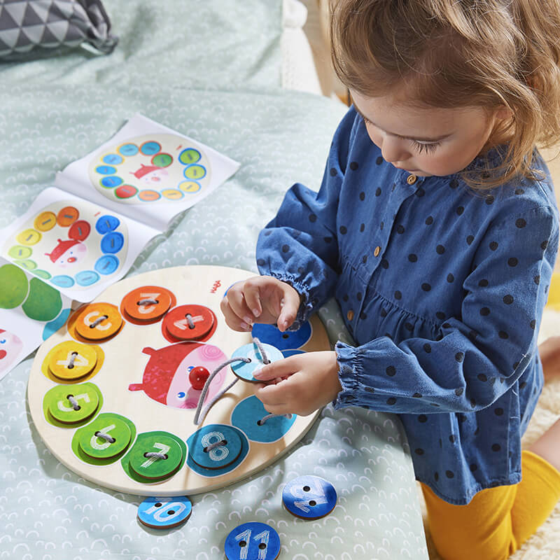 Kid playing with Rainbow Caterpillar Threading game